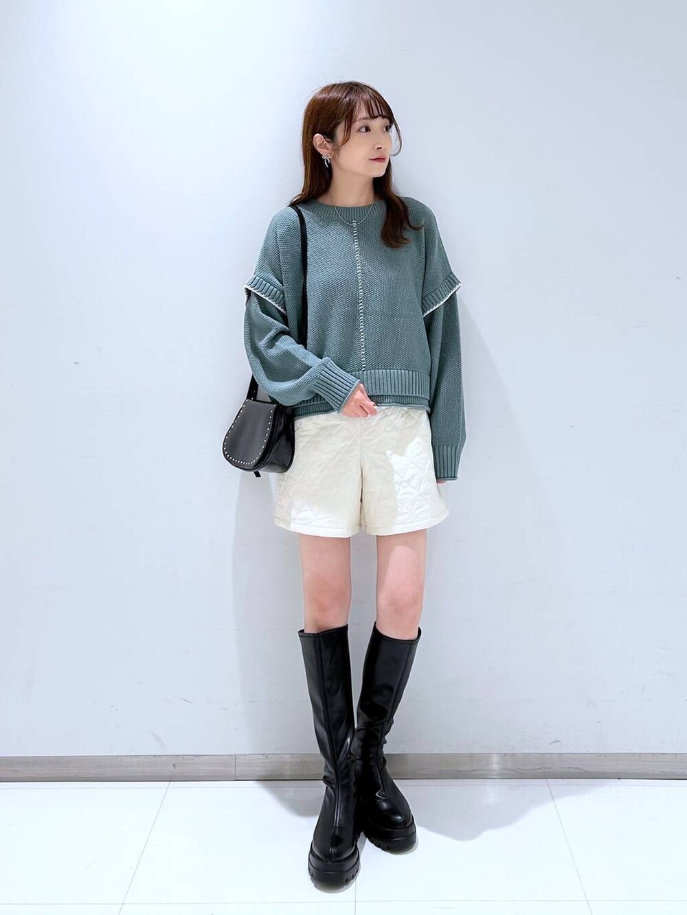 グリーン系のニット/セーター、ホワイト系のその他パンツ、ブラック系のショルダーバッグを着用したレディースの秋コーディネートの3枚目の写真