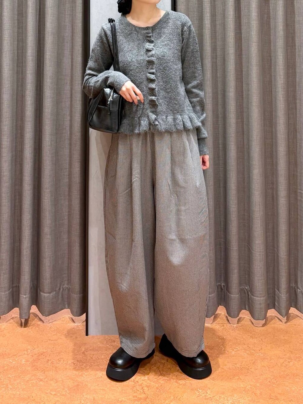 ブラック系のサンダル、ブラック系のボストンバッグ、グレー系のニット/セーターを着用したレディースの秋コーディネートの2枚目の写真