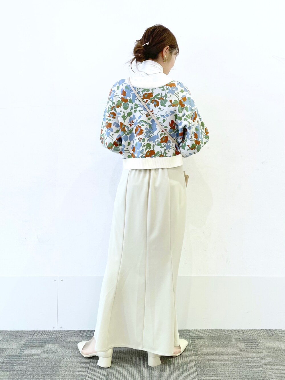 ホワイト系のパンプス、ホワイト系のスカート、ホワイト系のショルダーバッグを着用したレディースの冬コーディネートの2枚目の写真