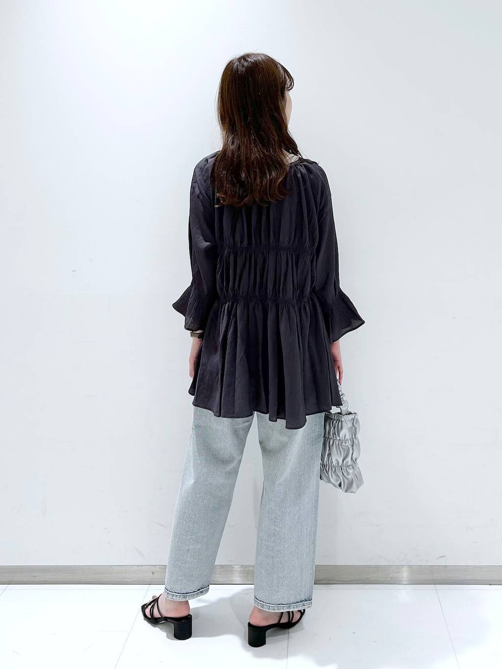 ホワイト系のTシャツ/カットソー、ブラック系のサンダル、ブルー系のデニムパンツを着用したレディースの春コーディネートの4枚目の写真