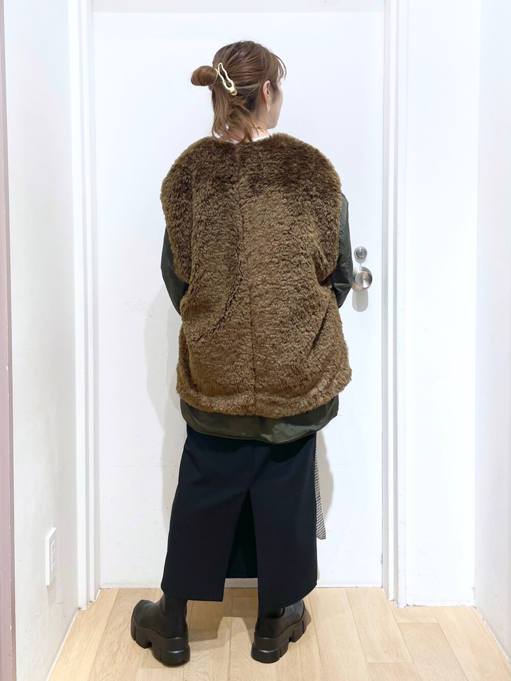 ブラック系のトートバッグ、グリーン系のブルゾン、ブラック系のブーツを着用したレディースの秋コーディネートの2枚目の写真