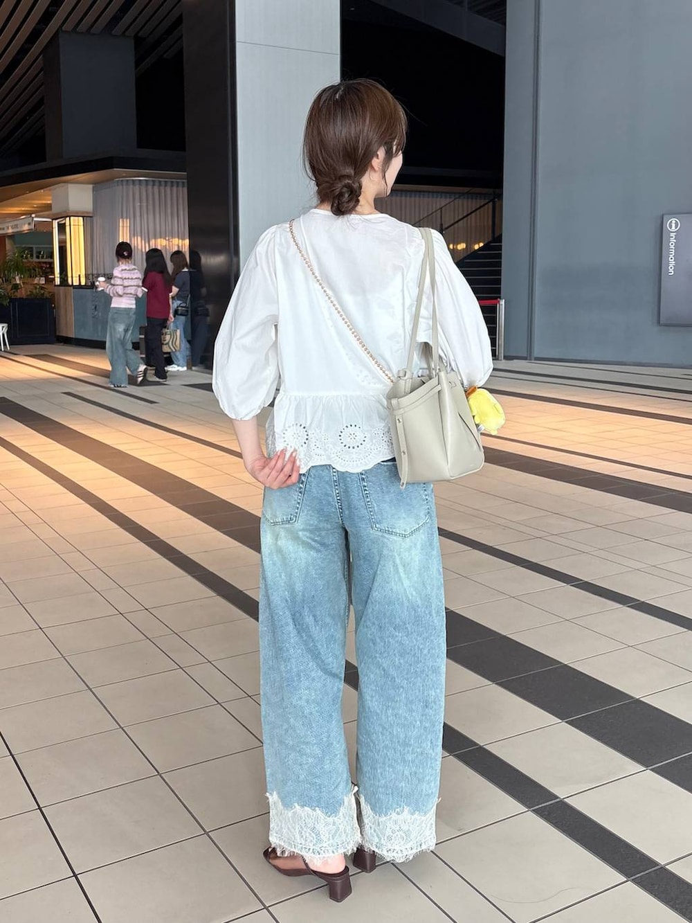 ゴールド系のショルダーバッグ、ブルー系のデニムパンツ、ホワイト系のシャツ/ブラウスを着用したレディースの夏コーディネートの5枚目の写真