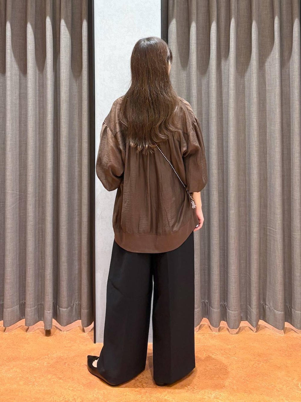 ゴールド系のショルダーバッグ、ベージュ系のキャミソール、ブラック系のワンピースを着用したレディースの秋コーディネートの4枚目の写真