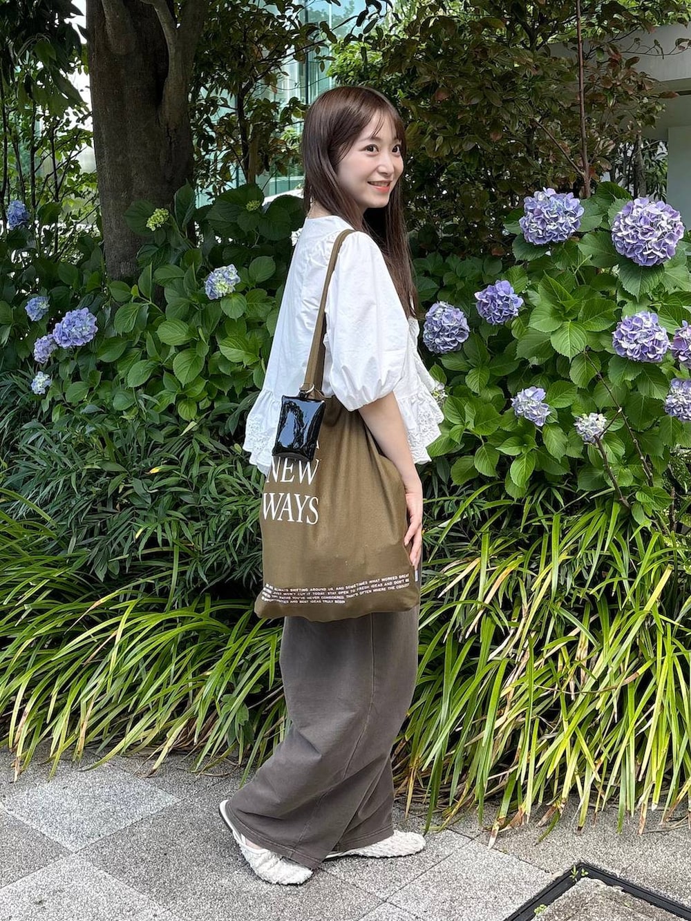 ホワイト系のパンプス、ホワイト系のシャツ/ブラウス、ゴールド系のチョーカーを着用したレディースの夏コーディネートの3枚目の写真