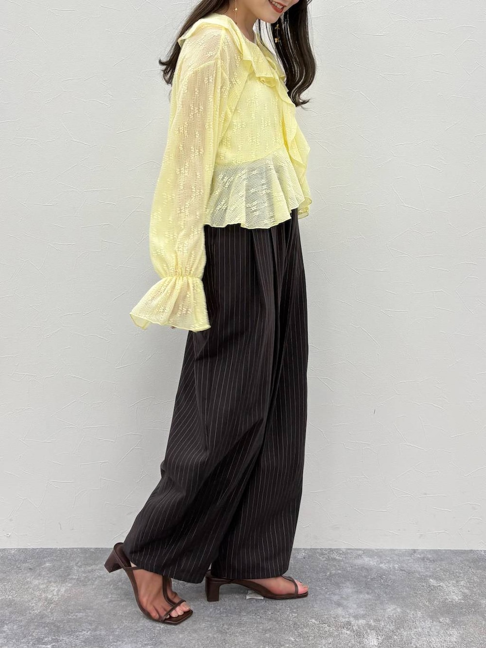 ブラウン系のその他パンツ、ブラウン系のサンダル、その他のキーホルダーを着用したレディースの春コーディネートの4枚目の写真