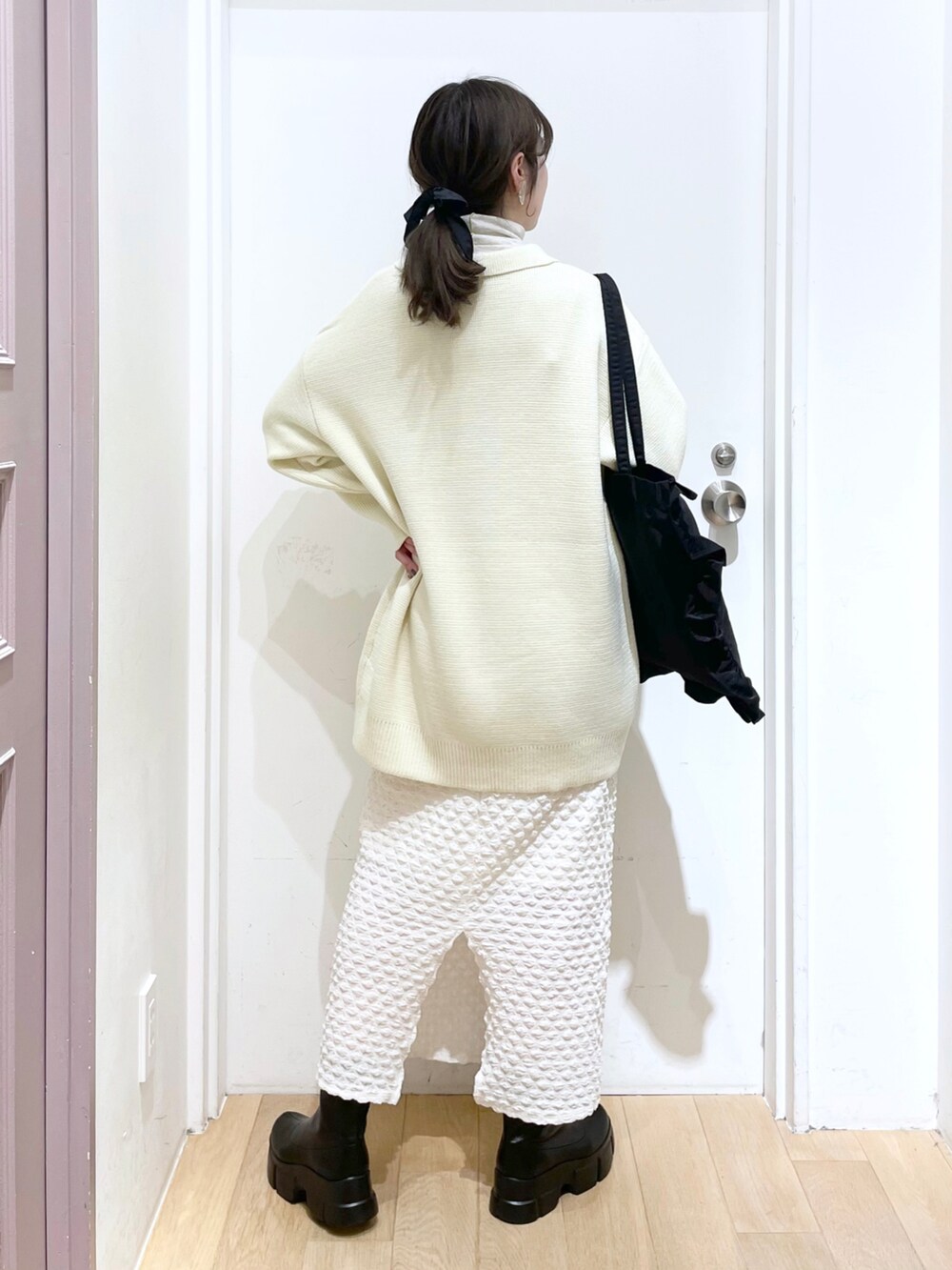 ブラック系のトートバッグ、ホワイト系のカーディガン/ボレロ、その他のTシャツ/カットソーを着用したレディースの春コーディネートの2枚目の写真