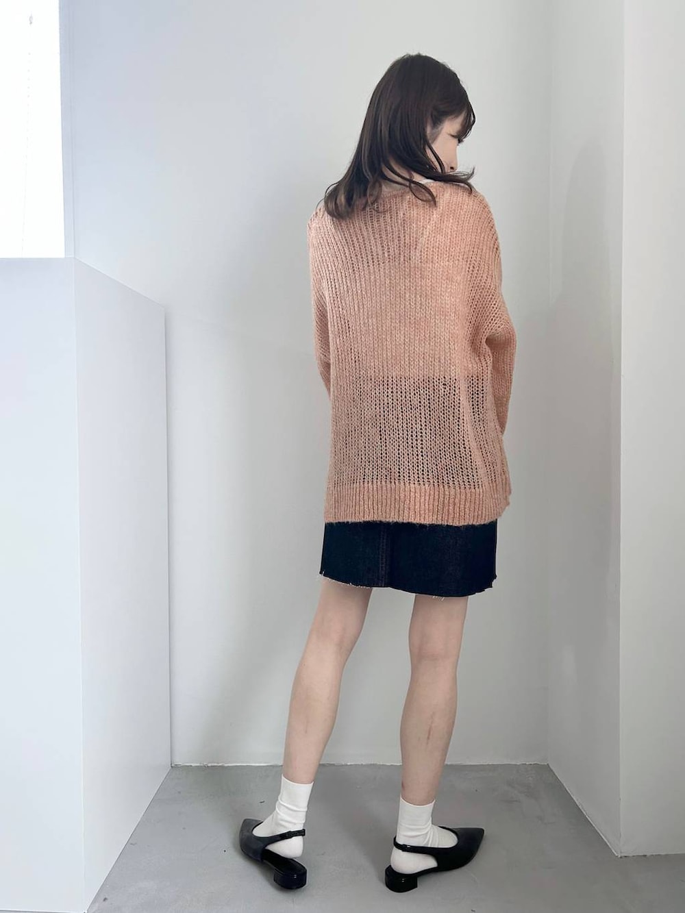 ブラック系のパンプス、ホワイト系のキャミソール、ブルー系のスカートを着用したレディースの冬コーディネートの4枚目の写真