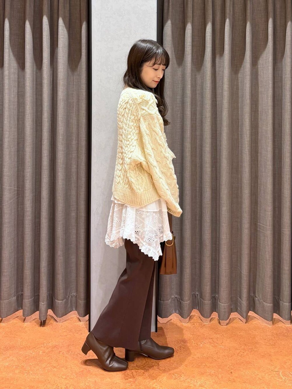 ブラウン系のその他パンツ、ホワイト系のスカート、ホワイト系のポロシャツを着用したレディースの秋コーディネートの3枚目の写真