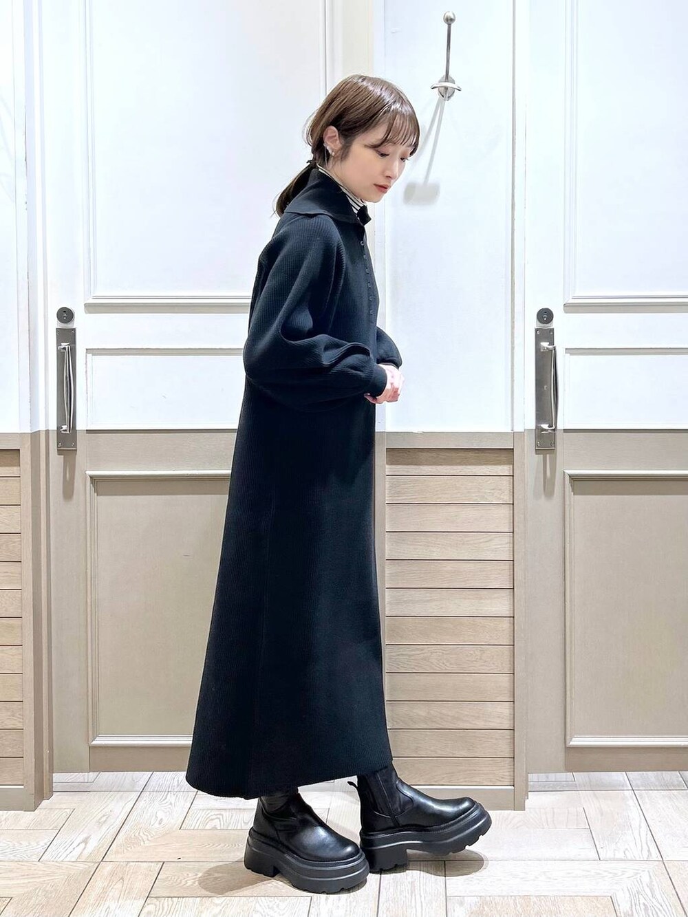 ホワイト系のTシャツ/カットソー、グリーン系のダウンジャケット/コート、ブラック系のブーツを着用したレディースの冬コーディネートの6枚目の写真