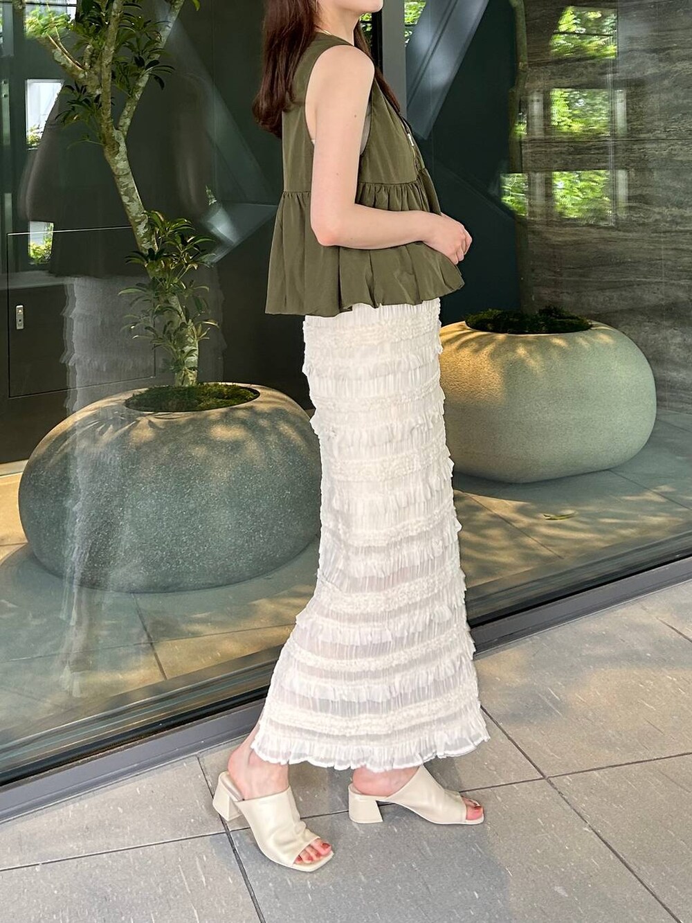 ホワイト系のTシャツ/カットソー、ホワイト系のサンダル、ホワイト系のスカートを着用したレディースの夏コーディネートの3枚目の写真