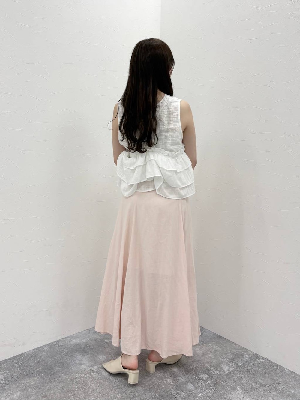 ホワイト系のTシャツ/カットソー、ホワイト系のサンダル、ピンク系のスカートを着用したレディースの春コーディネートの3枚目の写真
