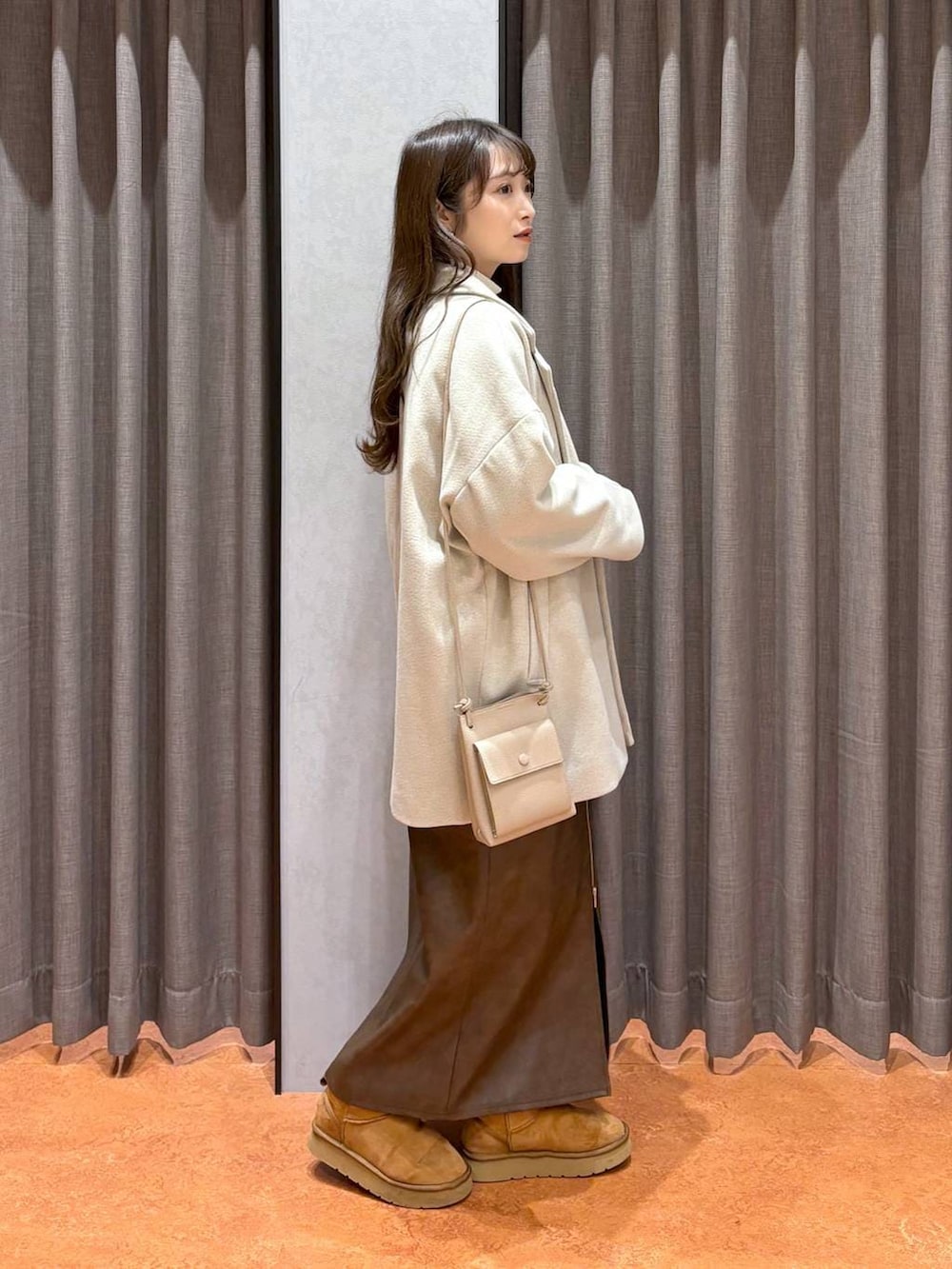 ホワイト系のニット/セーター、ホワイト系のその他アウター、ブラウン系のスカートを着用したレディースの冬コーディネートの2枚目の写真