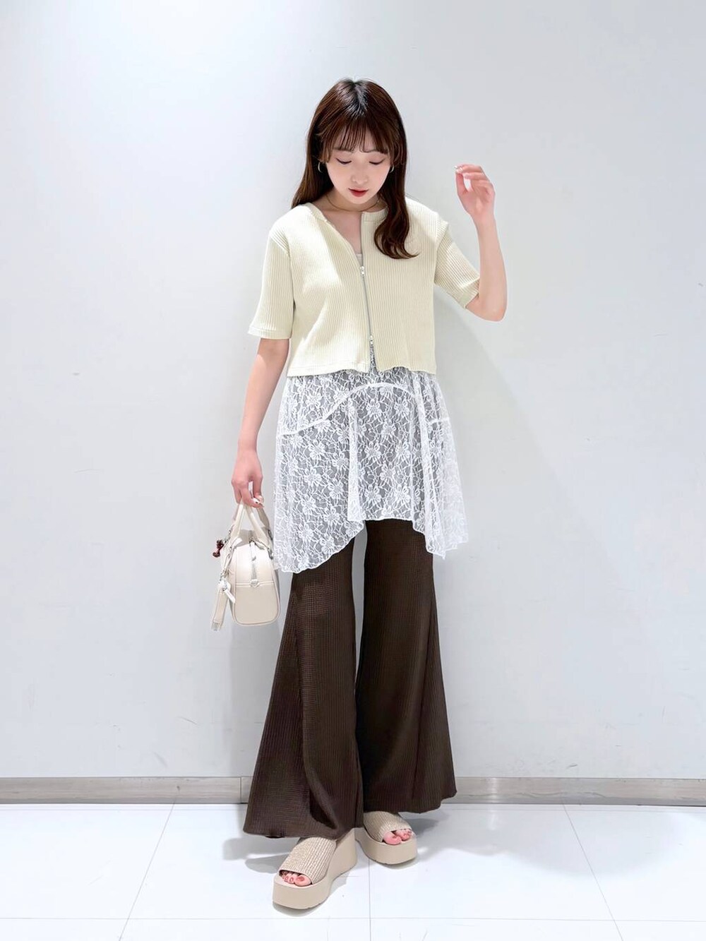 ホワイト系のTシャツ/カットソー、ホワイト系のサンダル、ブラウン系のその他パンツを着用したレディースの春コーディネートの2枚目の写真