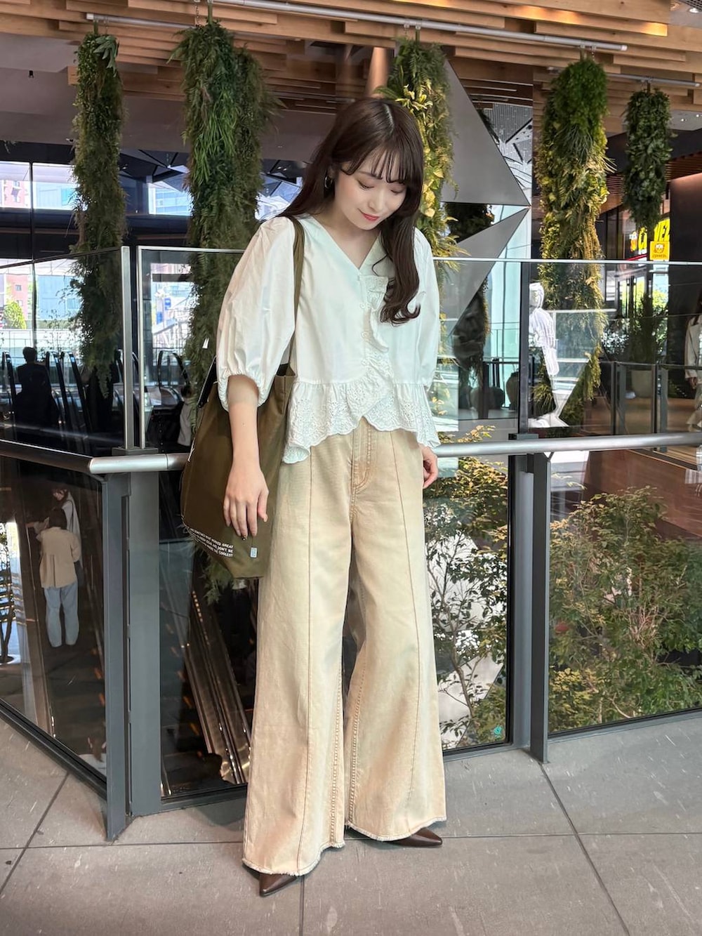オレンジ系のデニムパンツ、ホワイト系のシャツ/ブラウス、ブラウン系のサンダルを着用したレディースの春コーディネートの2枚目の写真