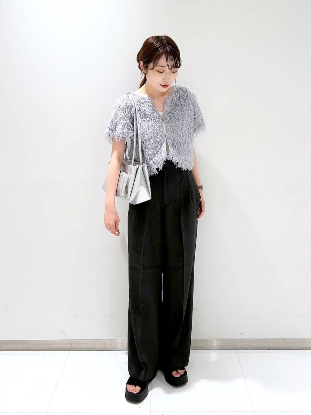 ブラック系のサンダル、ホワイト系のキャミソール、グレー系のスラックスを着用したレディースの夏コーディネートの2枚目の写真