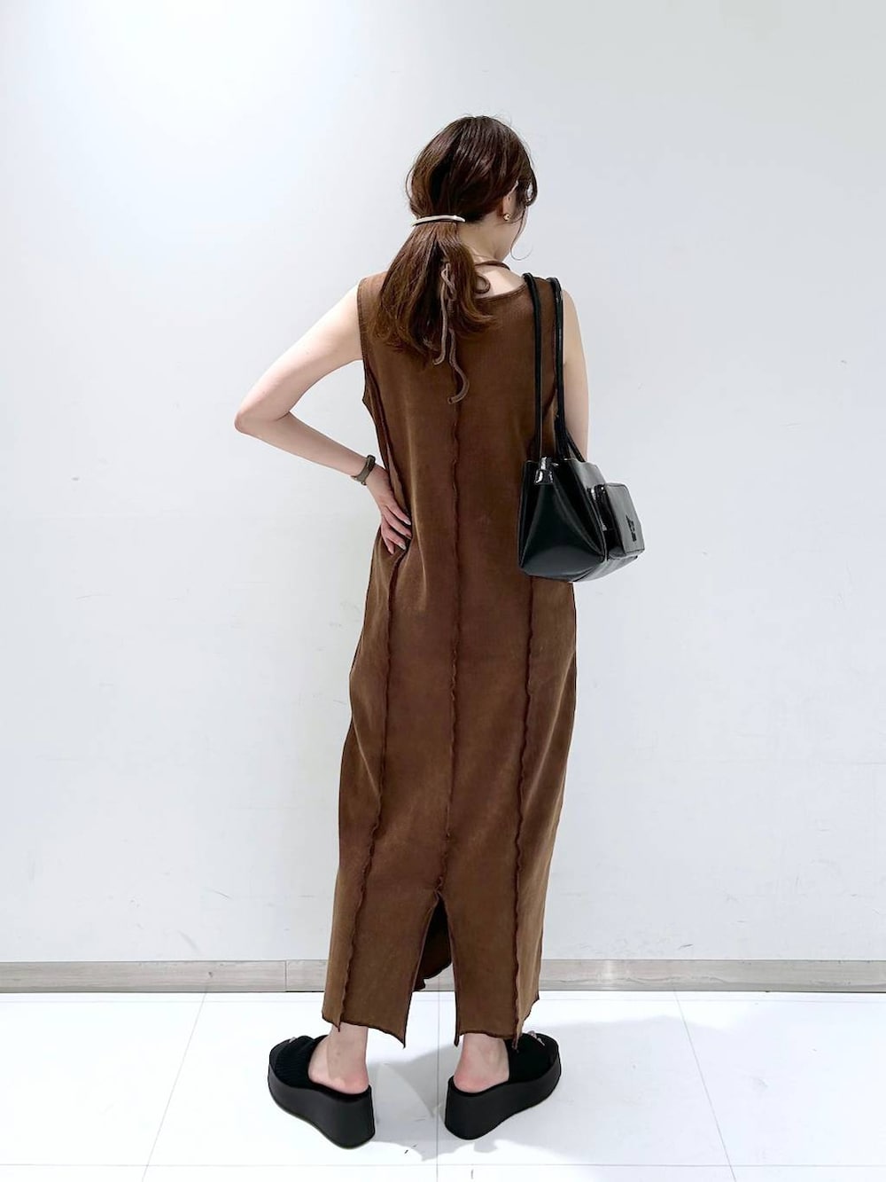 ブラック系のサンダル、ブラウン系のワンピース、ブラック系のショルダーバッグを着用したレディースの夏コーディネートの4枚目の写真