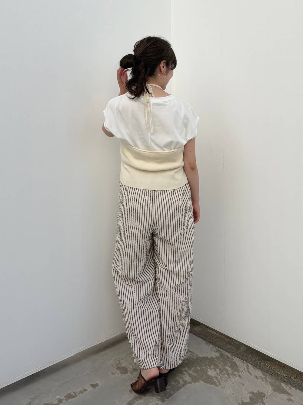 ホワイト系のTシャツ/カットソー、ホワイト系のキャミソール、ブラウン系のサンダルを着用したレディースの秋コーディネートの4枚目の写真