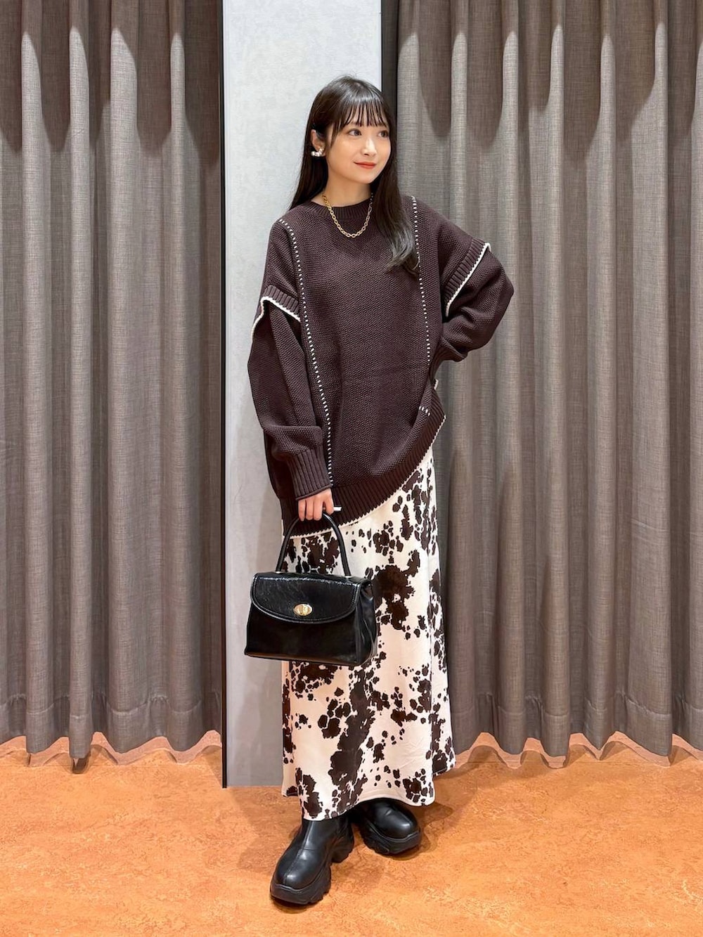 ブラック系のブーツ、その他のスカート、ブラウン系のニット/セーターを着用したレディースの冬コーディネートの5枚目の写真