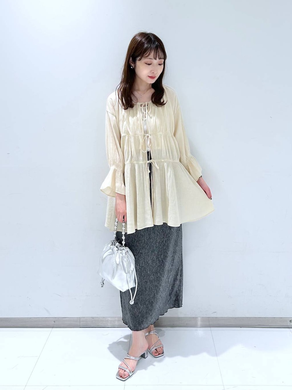 ホワイト系のTシャツ/カットソー、シルバー系のサンダル、シルバー系のショルダーバッグを着用したレディースの春コーディネートの2枚目の写真