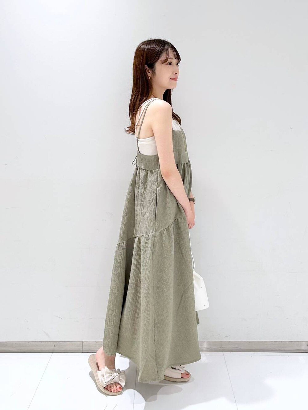 ホワイト系のTシャツ/カットソー、グリーン系のワンピース、ホワイト系のショルダーバッグを着用したレディースの夏コーディネートの4枚目の写真