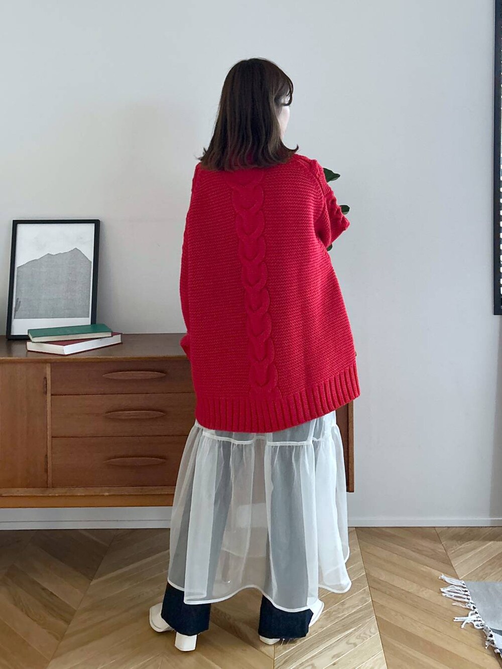 ブルー系のデニムパンツ、ホワイト系のパンプス、ホワイト系のスカートを着用したレディースの秋コーディネートの5枚目の写真