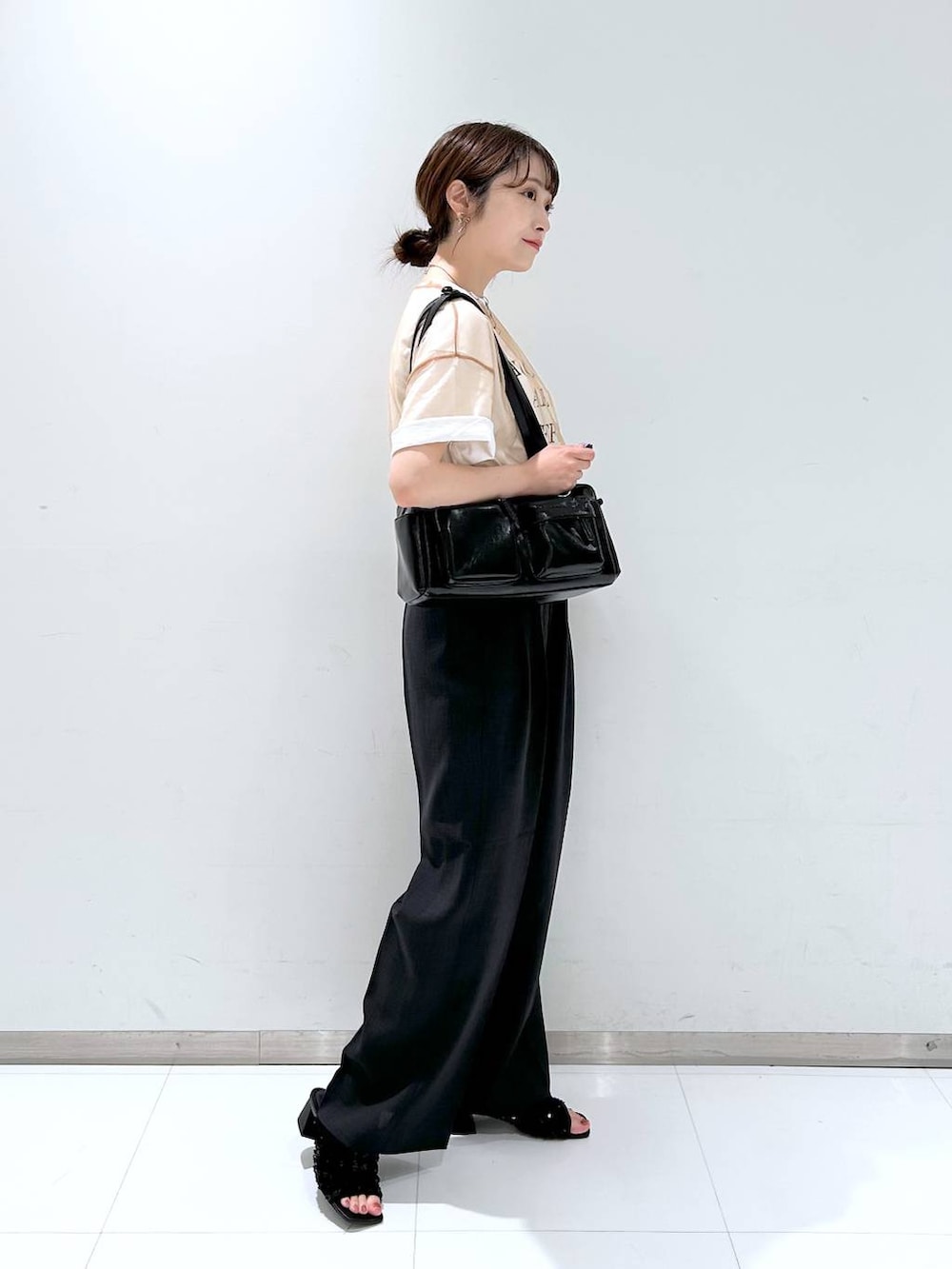 ブラック系のサンダル、ブラウン系のシャツ/ブラウス、ホワイト系のTシャツ/カットソーを着用したレディースの夏コーディネートの3枚目の写真