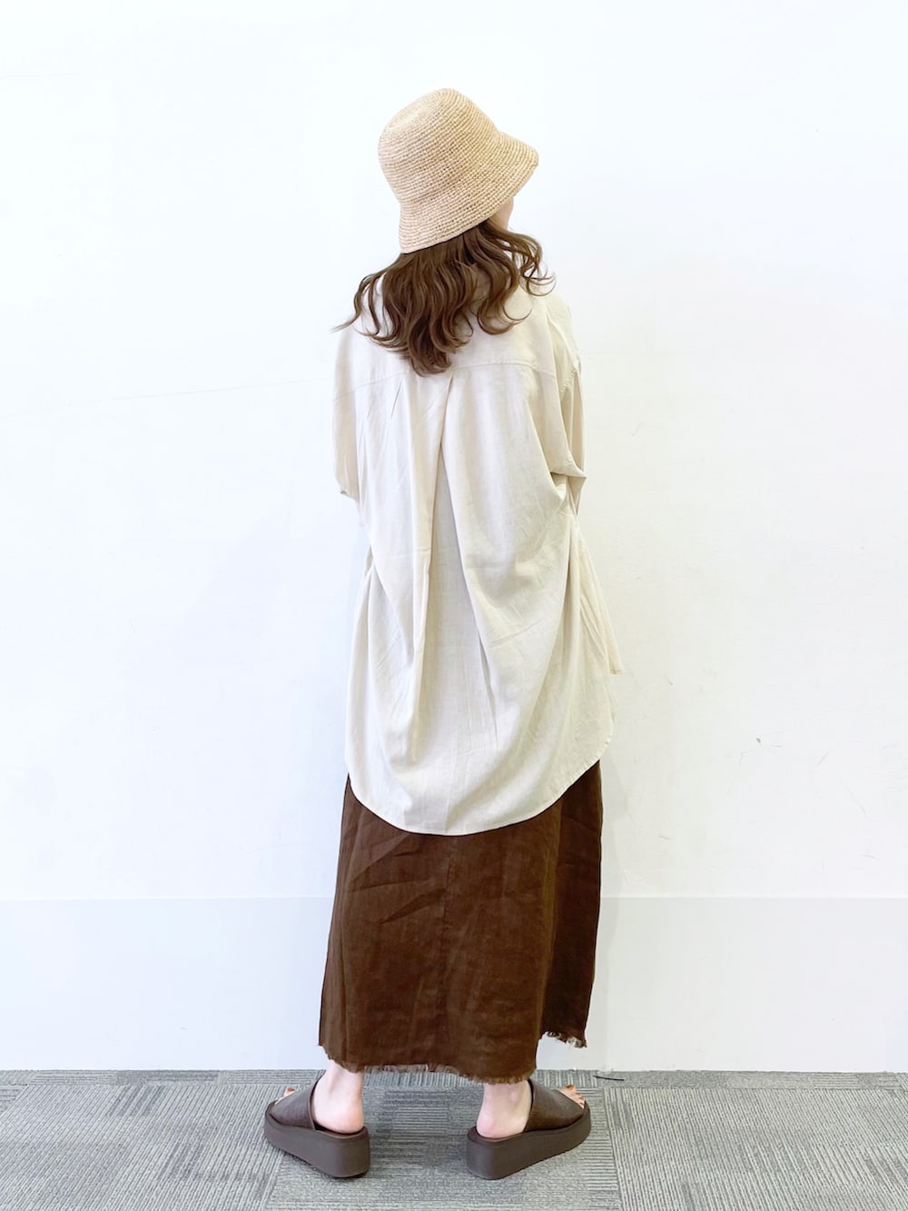 ブラウン系のサンダル、ホワイト系のショルダーバッグ、ブラウン系のスカートを着用したレディースの春コーディネートの2枚目の写真