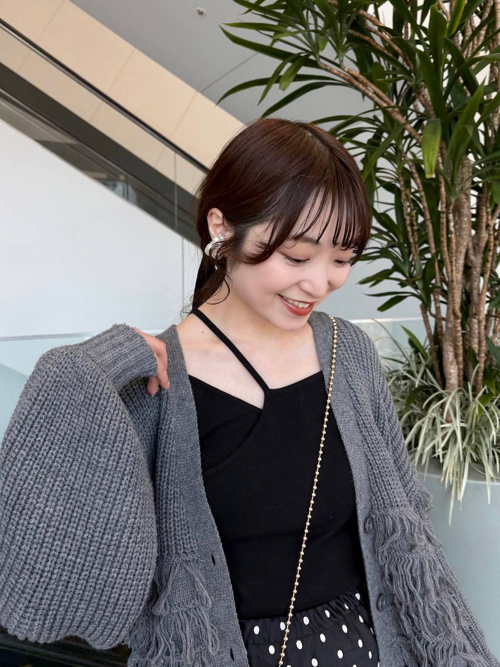 ゴールド系のショルダーバッグ、ブラック系のスカートを着用したレディースの春コーディネートの9枚目の写真