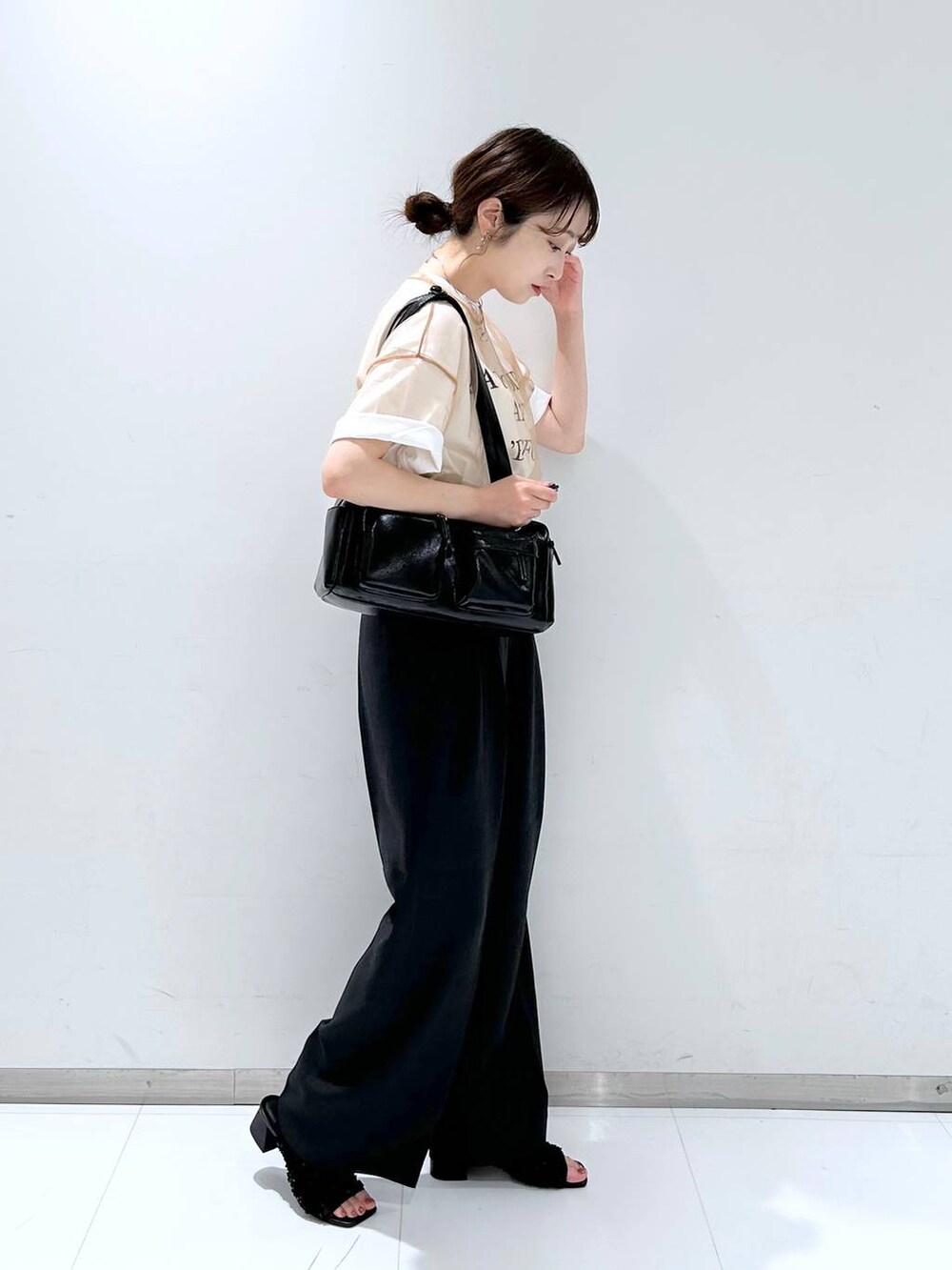 ブラック系のサンダル、ブラウン系のシャツ/ブラウス、ホワイト系のTシャツ/カットソーを着用したレディースの夏コーディネートの4枚目の写真