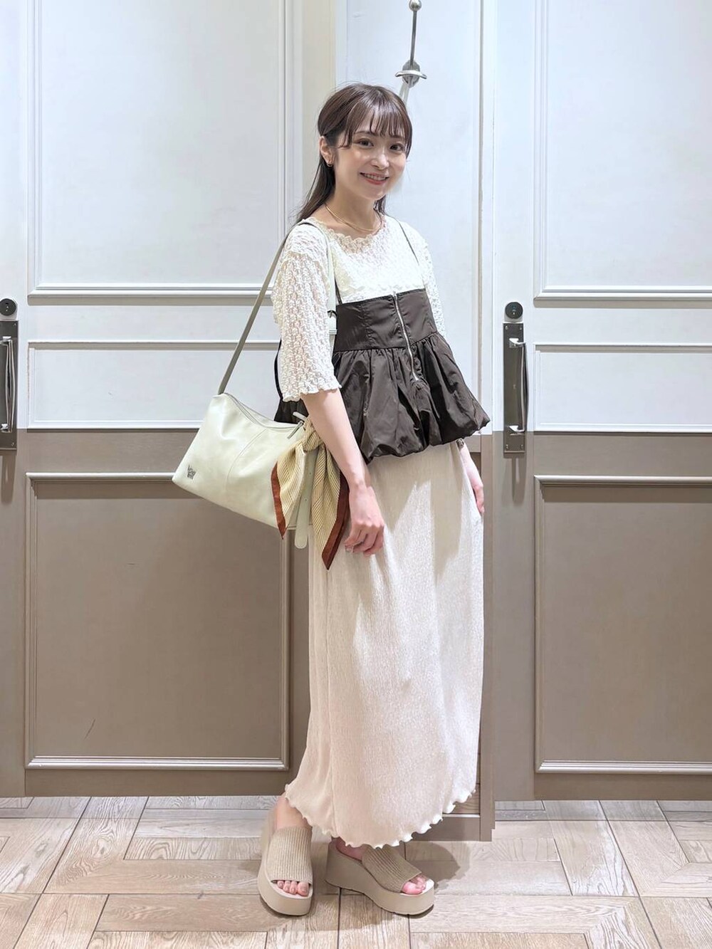 ホワイト系のTシャツ/カットソー、ホワイト系のサンダル、ブラック系のショルダーバッグを着用したレディースの春コーディネートの2枚目の写真