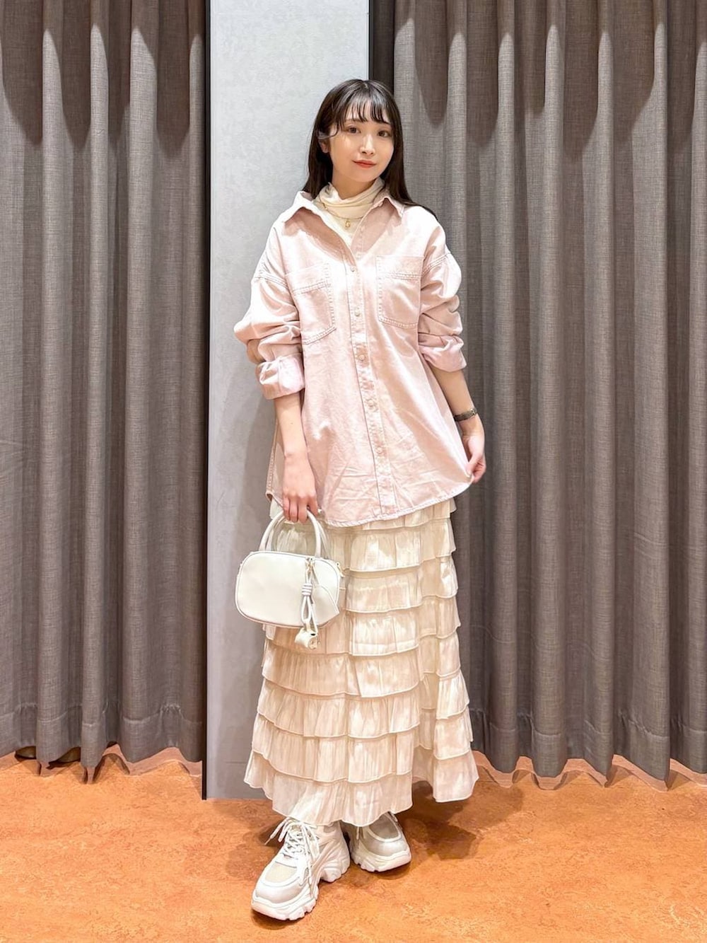 ホワイト系のスカート、ホワイト系のボストンバッグ、ピンク系のシャツ/ブラウスを着用したレディースの冬コーディネートの2枚目の写真