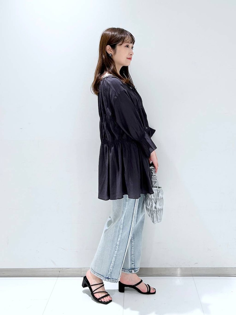 ホワイト系のTシャツ/カットソー、ブラック系のサンダル、ブルー系のデニムパンツを着用したレディースの春コーディネートの3枚目の写真