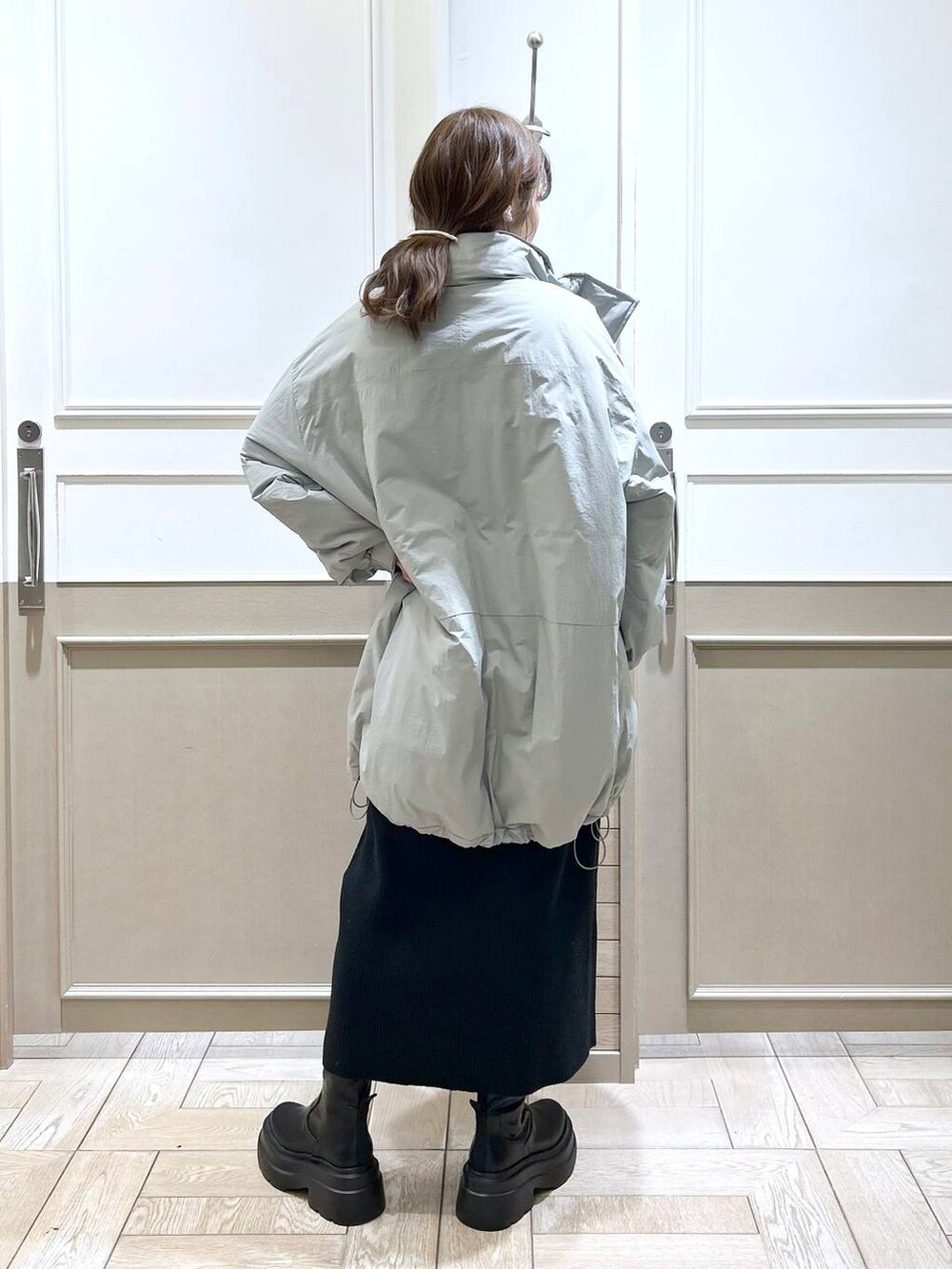 ホワイト系のTシャツ/カットソー、グリーン系のダウンジャケット/コート、ブラック系のブーツを着用したレディースの冬コーディネートの4枚目の写真