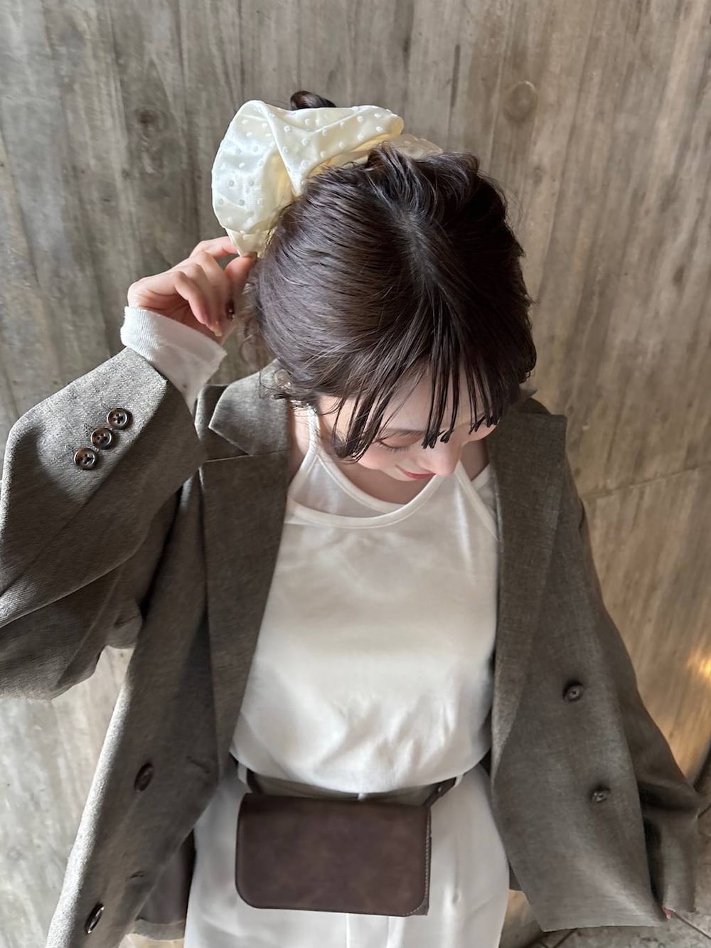 ブラウン系のテーラードジャケット、ブラウン系のローファー、ブラウン系のボディバッグ/ウエストポーチを着用したレディースの春コーディネートの2枚目の写真