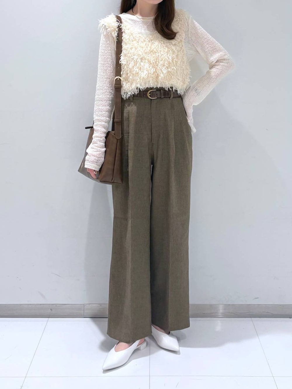 ブラウン系のスラックス、ホワイト系のパンプス、ホワイト系のTシャツ/カットソーを着用したレディースの春コーディネートの2枚目の写真