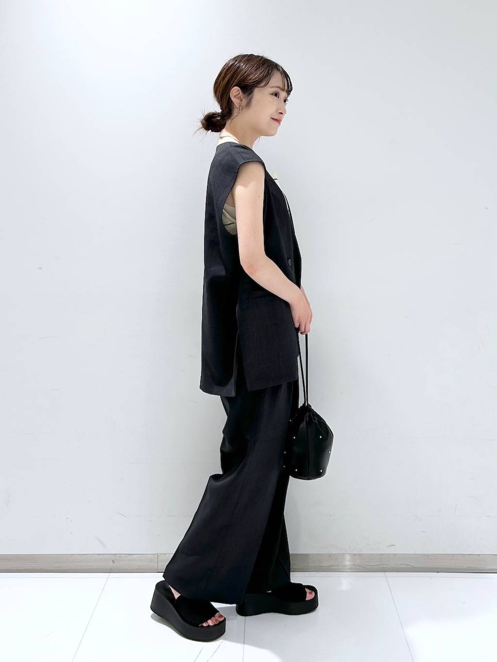 ブラック系のサンダル、ブラック系のショルダーバッグ、ホワイト系のタンクトップを着用したレディースの夏コーディネートの4枚目の写真