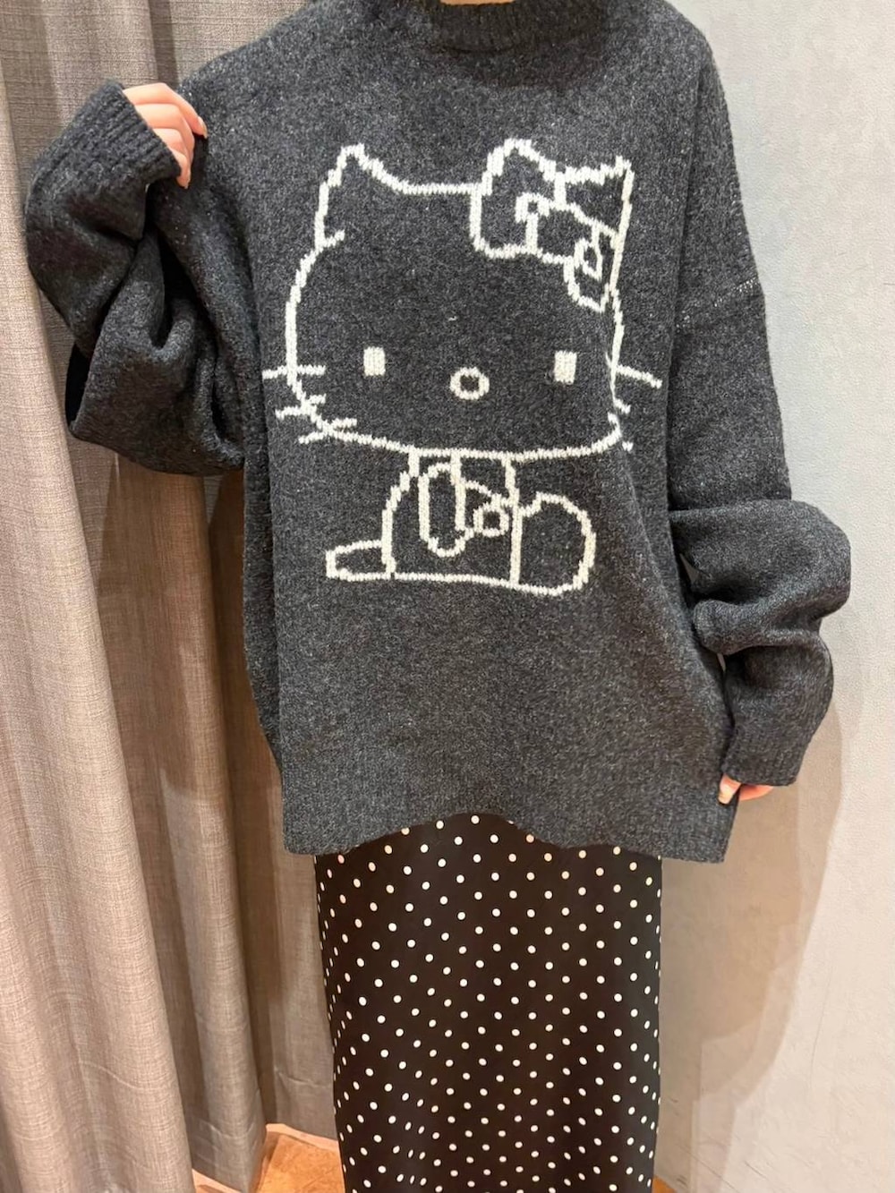 ブラック系のスカート、ホワイト系のスカート、グレー系のニット/セーターを着用したレディースの秋コーディネートの3枚目の写真