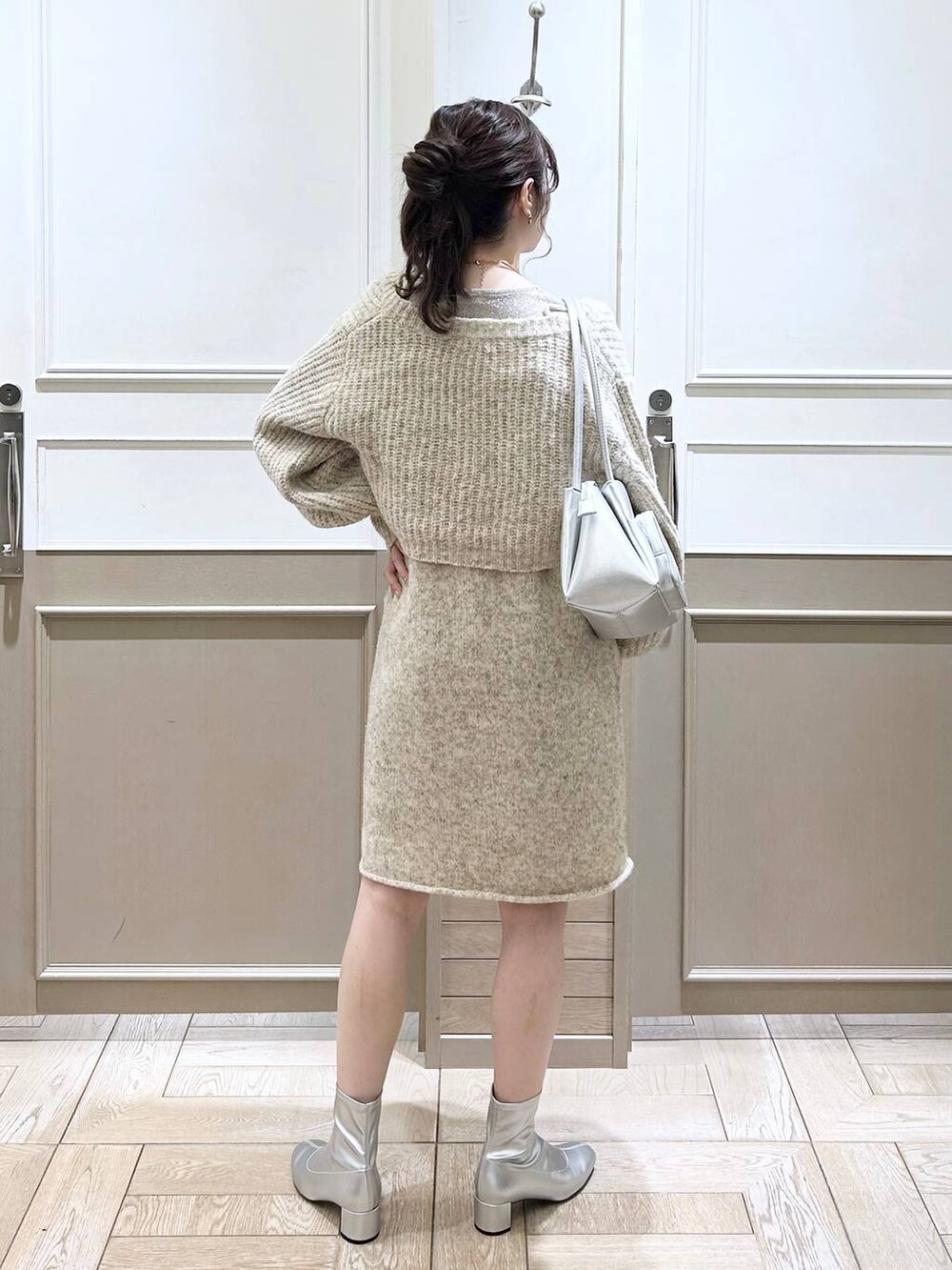 シルバー系のショルダーバッグ、ホワイト系のTシャツ/カットソー、シルバー系のブーツを着用したレディースの冬コーディネートの3枚目の写真