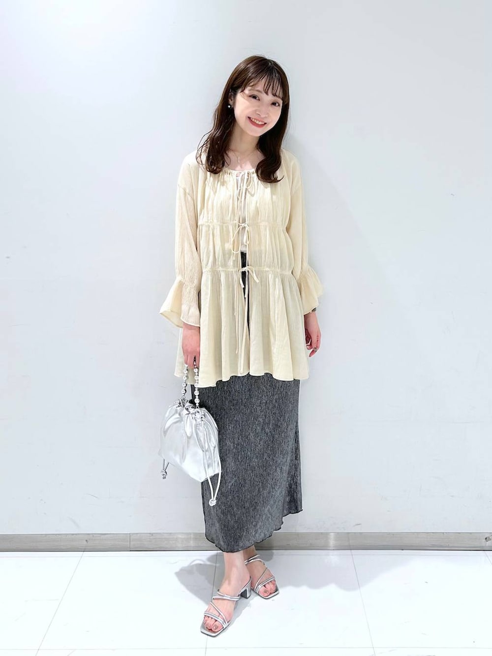 ホワイト系のTシャツ/カットソー、シルバー系のサンダル、シルバー系のショルダーバッグを着用したレディースの春コーディネートの3枚目の写真