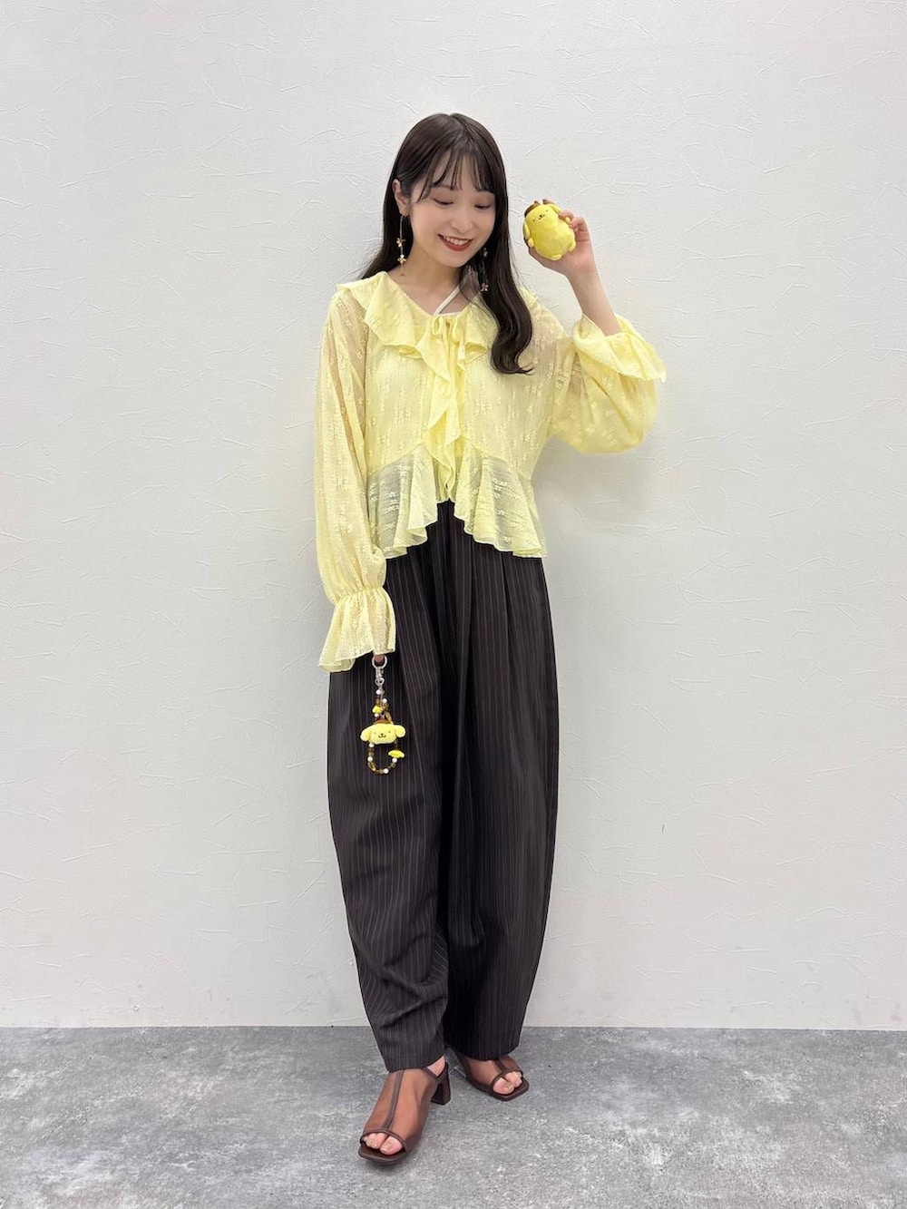 ブラウン系のその他パンツ、ブラウン系のサンダル、その他のキーホルダーを着用したレディースの春コーディネートの2枚目の写真