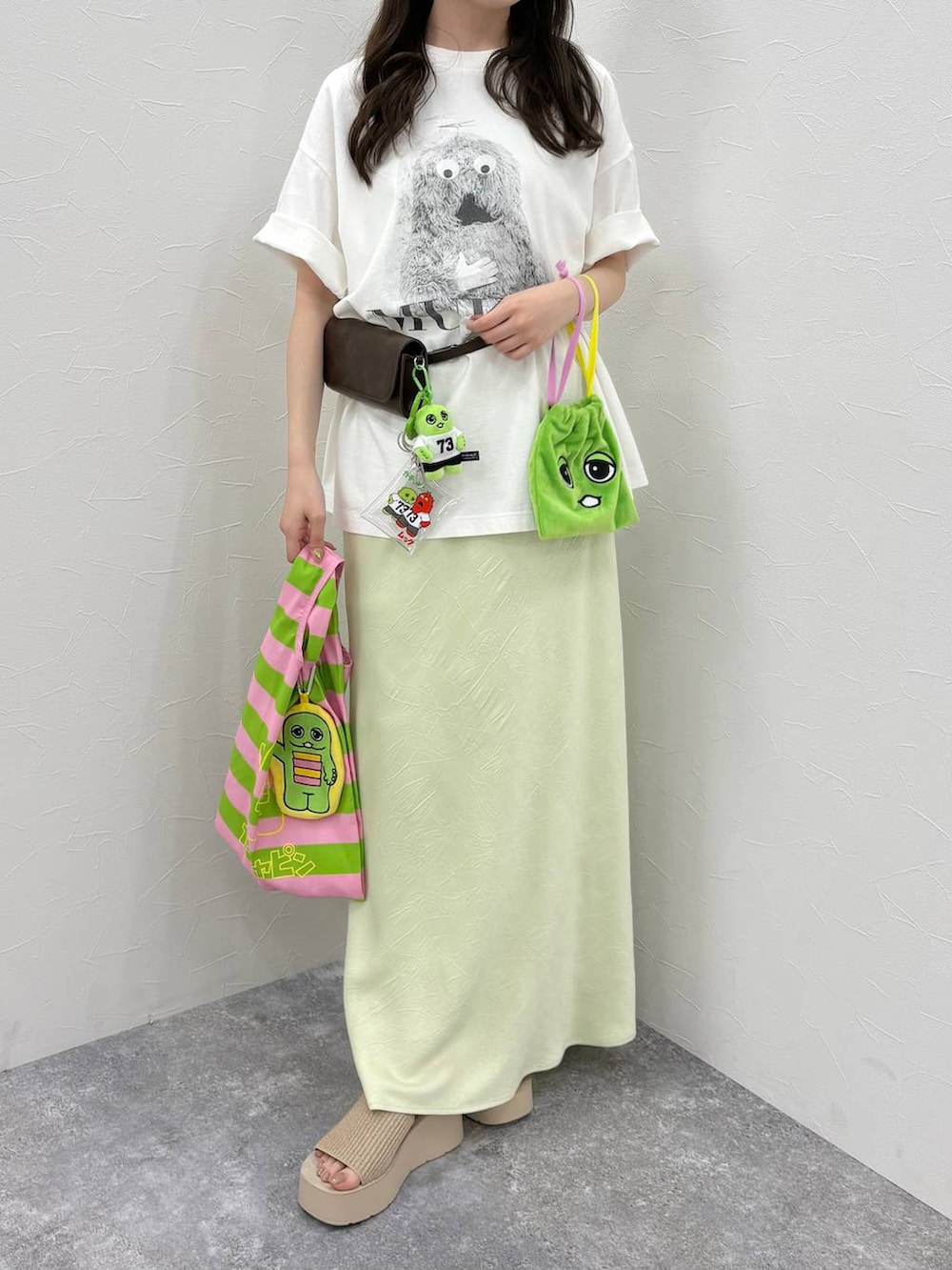 グリーン系のスカート、ホワイト系のサンダル、その他のエコバッグ/サブバッグを着用したレディースの春コーディネートの4枚目の写真