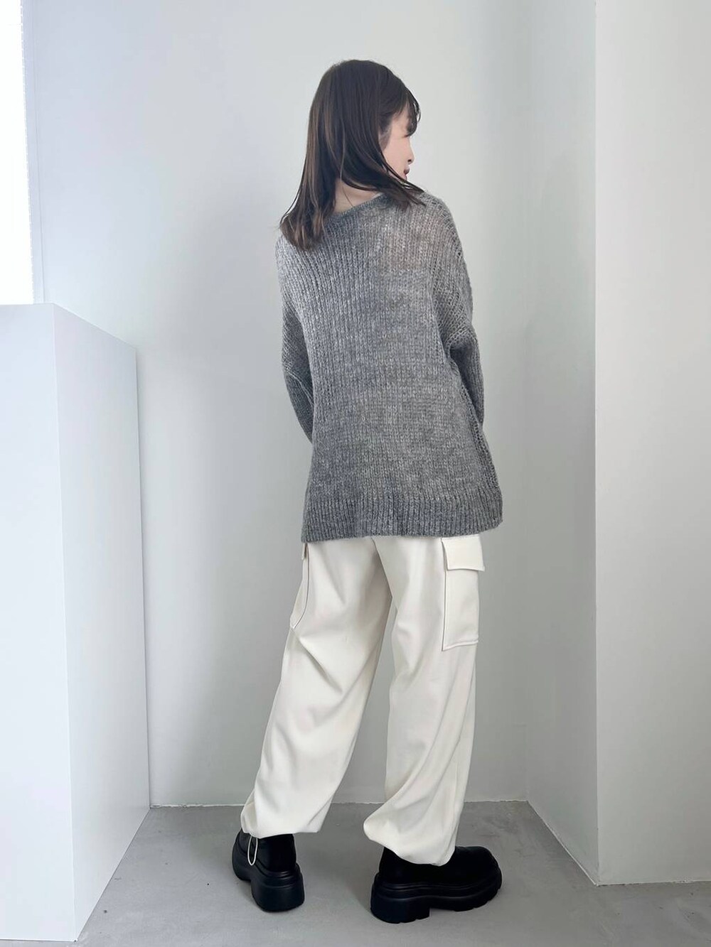 ホワイト系のキャミソール、ブラック系のブーツ、ホワイト系のカーゴパンツを着用したレディースの冬コーディネートの4枚目の写真