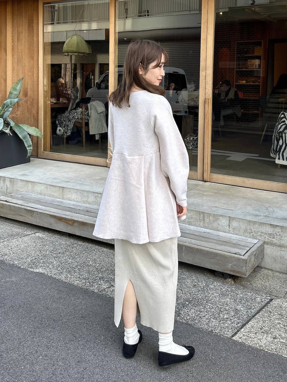 ホワイト系のニット/セーター、グレー系のスカート、ゴールド系のイヤリングを着用したレディースの冬コーディネートの3枚目の写真