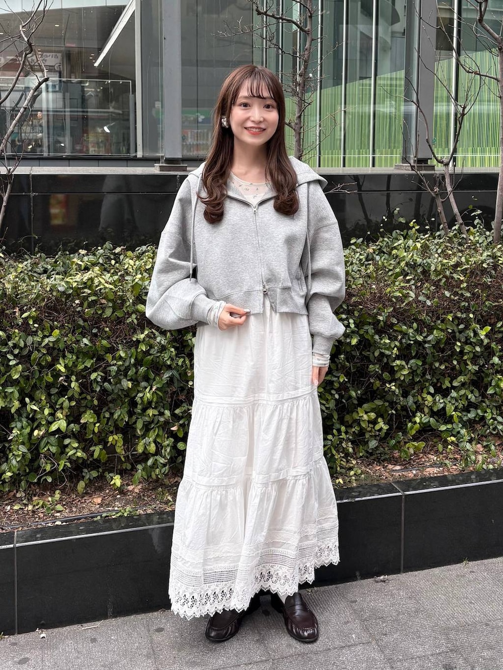 グレー系のパーカー、ホワイト系のTシャツ/カットソー、ブラウン系のローファーを着用したレディースの冬コーディネートの4枚目の写真