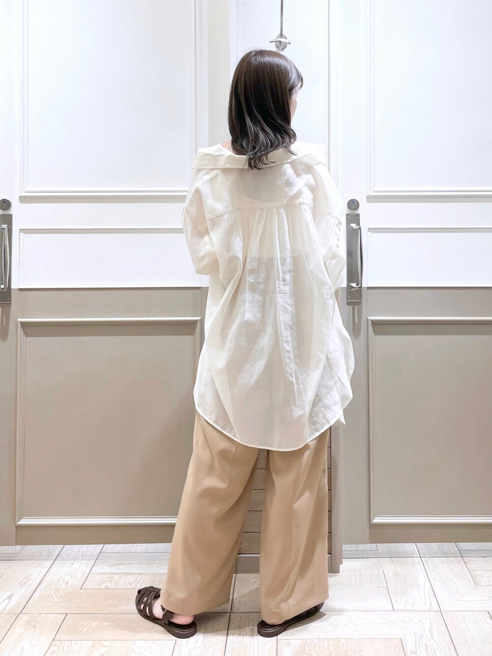 ホワイト系のタンクトップ、ホワイト系のシャツ/ブラウス、ホワイト系のショルダーバッグを着用したレディースの春コーディネートの2枚目の写真