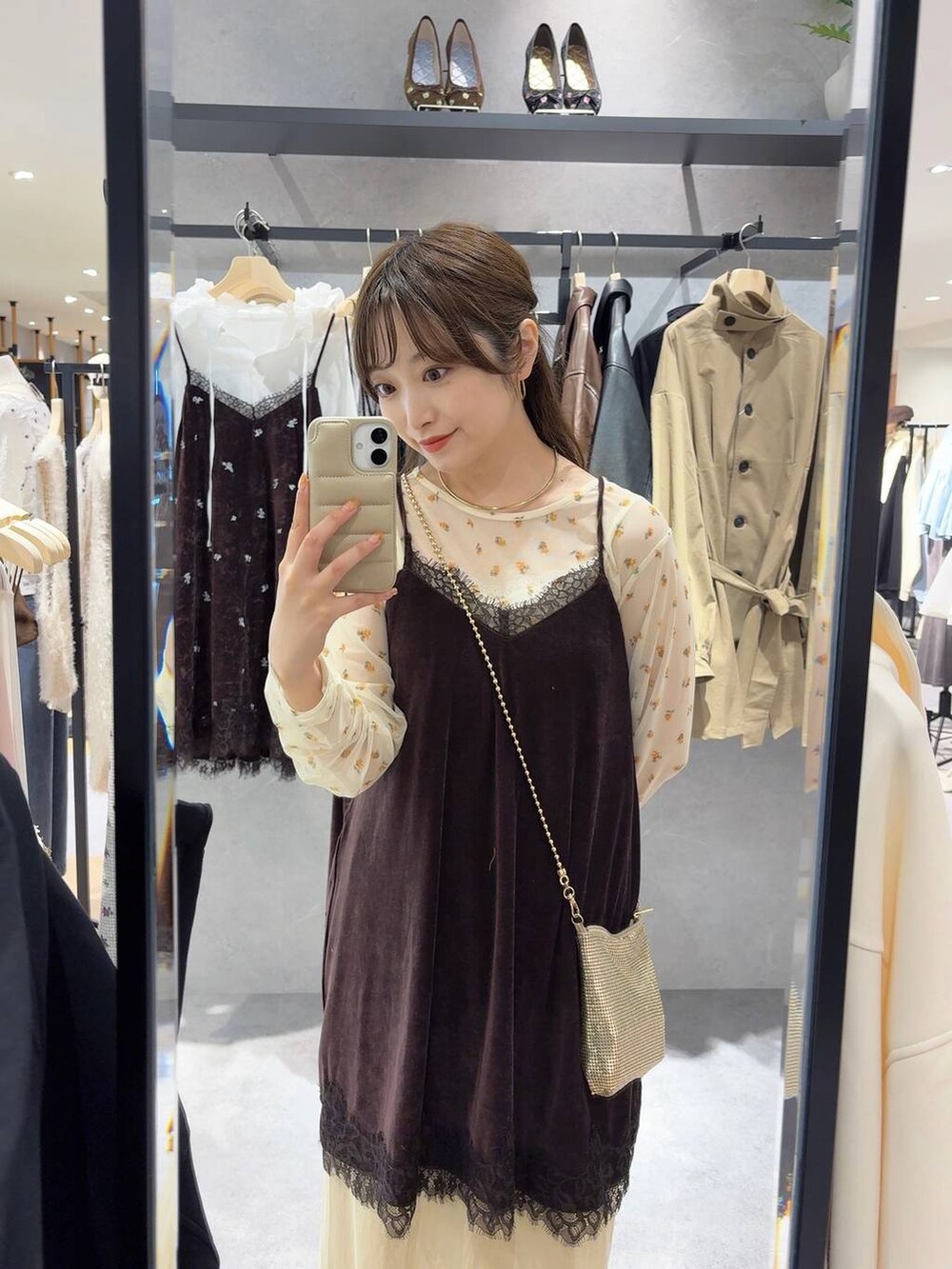 ゴールド系のショルダーバッグ、ブルー系のデニムパンツ、ホワイト系のシャツ/ブラウスを着用したレディースの秋コーディネートの4枚目の写真