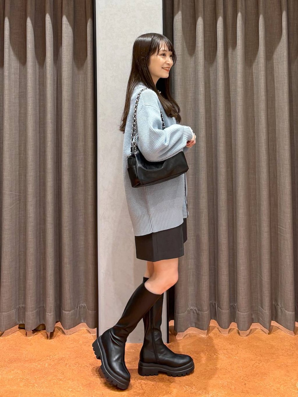 ブルー系のカーディガン/ボレロ、グレー系のその他パンツ、ブラック系のブーツを着用したレディースの冬コーディネートの4枚目の写真