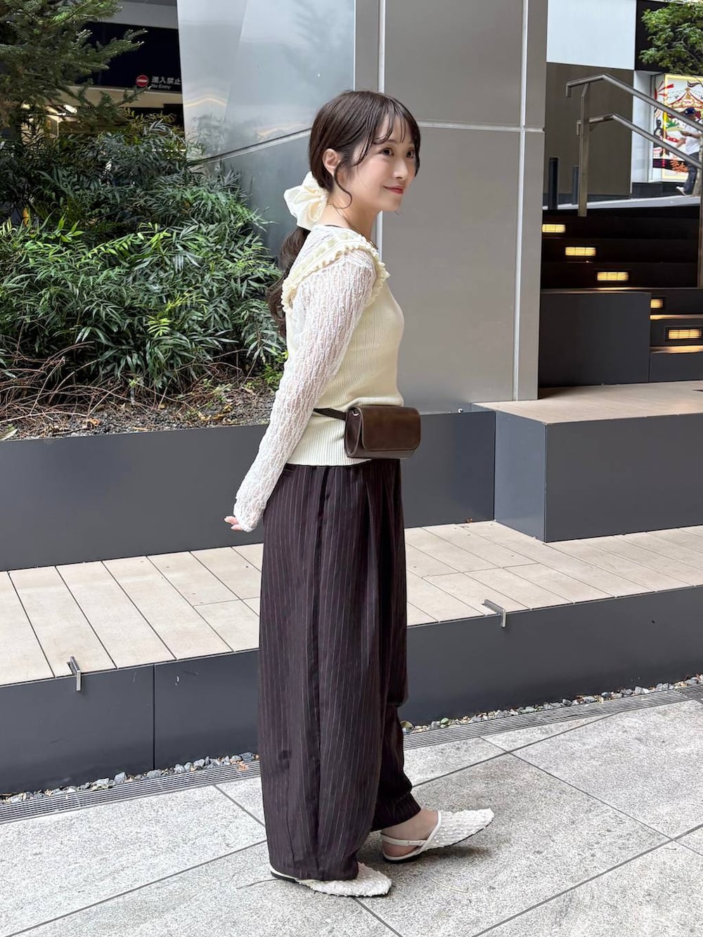 ブラウン系のその他パンツ、ホワイト系のタンクトップ、ブラウン系のボディバッグ/ウエストポーチを着用したレディースの春コーディネートの3枚目の写真
