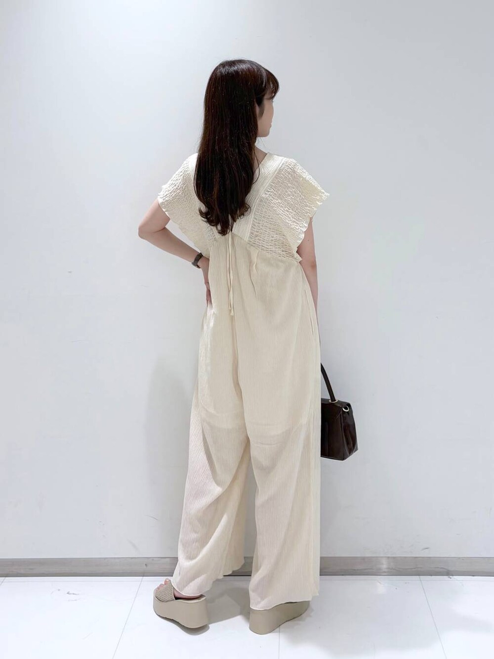 ホワイト系のサンダル、ホワイト系のサロペット/オーバーオール、ブラウン系のボストンバッグを着用したレディースの夏コーディネートの6枚目の写真