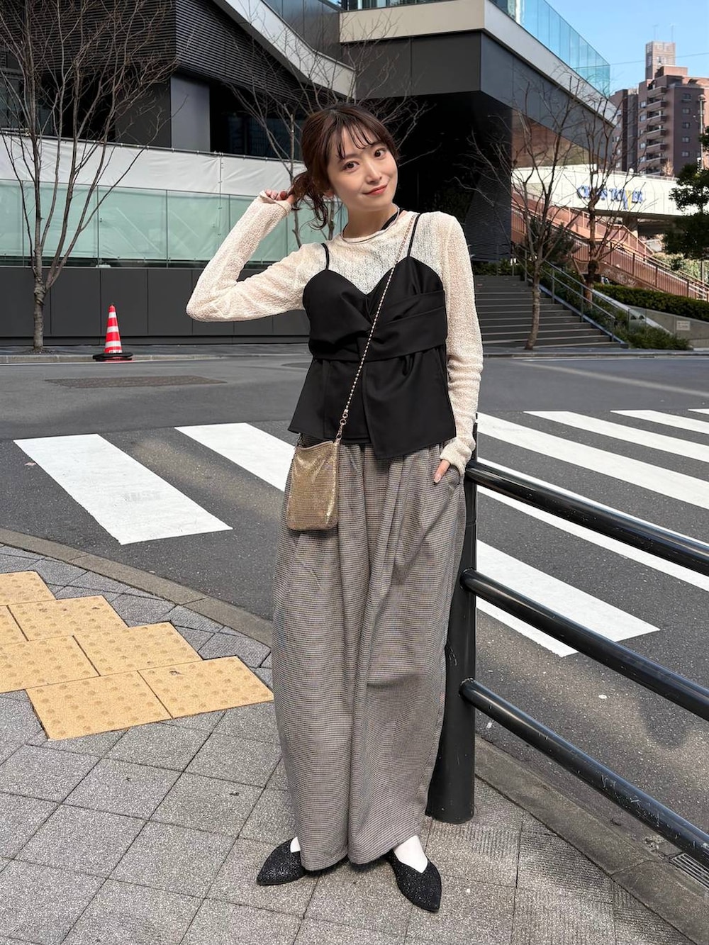 ゴールド系のショルダーバッグ、ブラック系のパンプス、ゴールド系のチョーカーを着用したレディースの春コーディネートの7枚目の写真